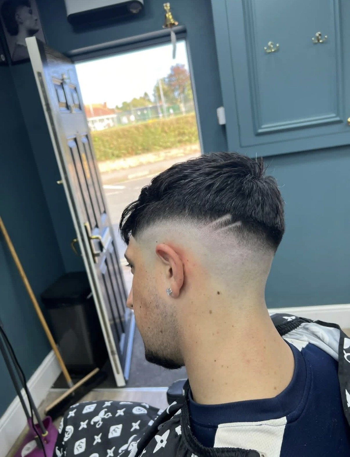 Sharp skin fade finished in the doorway of Cygneture Barbers, Swanland